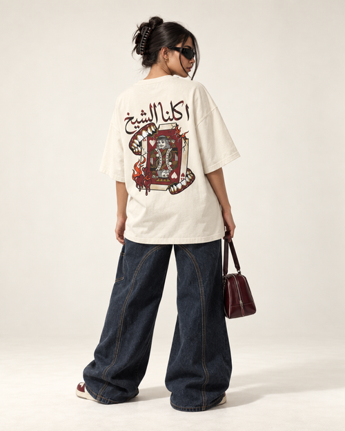 Model showing the Arabic lettering and illustrated back graphic on an ivory Monani Akalna Sheikh T-shirt