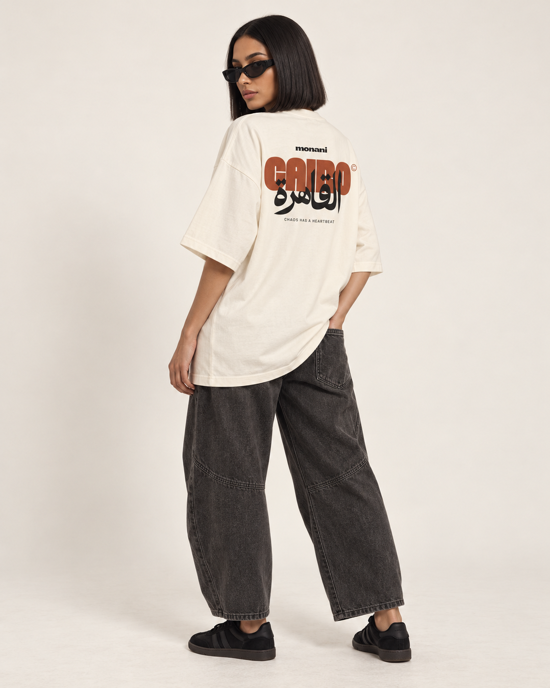 Model showing the red and black Cairo back graphic on an ivory Monani T-shirt
