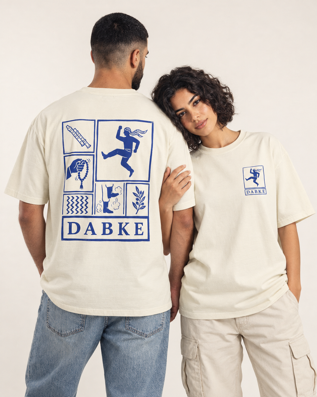 Two models showing the blue dance graphics on the front and back of ivory Monani Dabke T-shirts