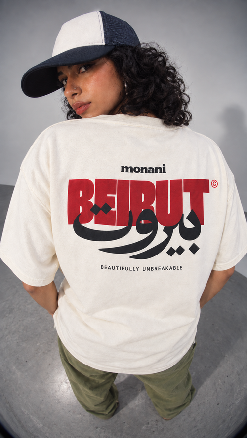 Model showing the red, black and Arabic Beirut back graphic on a white Monani T-shirt